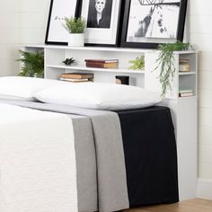 a bed with two pictures on the wall above it and a black and white bedspread