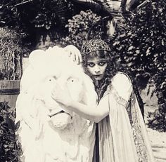 an old photo of two women dressed in costume and holding a large stuffed animal bear