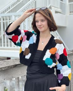 Introducing the "Confetti Geometry Jacket" - a modern crochet masterpiece that combines fun and fashion into a one-of-a-kind garment! This jacket is a bold statement piece with its playful design and vibrant color palette, perfect for any season. Features: Polka-Dot Inspired Design: With its large, colorful circles in shades of pink, teal, yellow, brown, and more, set against a striking black and white backdrop, this jacket takes inspiration from geometric shapes, creating a fun and artistic look that truly stands out. Cropped Silhouette: The trendy cropped style makes this jacket a perfect match for high-rise jeans, skirts, or even layered over dresses, giving you versatility in styling options. Three-Quarter Sleeves: The wide sleeves give it a relaxed and comfortable fit while adding a t Black And White Backdrop, Ponytail Hat Pattern, Granny Square Cardigan, Square Cardigan, Unique Jackets, Rose Bleu, Teal Yellow, Elegant Themes, Modern Crochet