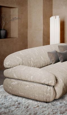 a couch with pillows on top of it in front of a wall mounted radiator