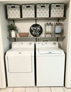 a washer and dryer sitting in a room next to some shelves with baskets on them