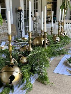 a table topped with lots of candles and greenery