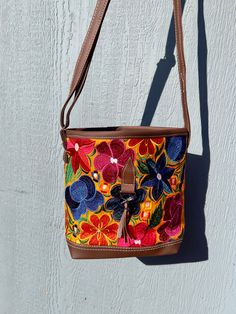 *Please advise each bag has a different design and color background. It might not be the exact flowers/ color background as the image. If you want a specific design please message us for photos* The vibrant embroidered flowers that are carefully crafted by artisans in Mexico bring beauty to this bag. You can style this as a shoulder or crossbody bag for any occasion.Measurements: 10 inches (width) x 8 1/2 (length)Made with Synthetic Faux Leather-Adjustable straps-Zipper closure pocket-Back Zippe Bohemian Everyday Flower Shoulder Bag, Multicolor Flower Shaped Shoulder Bag For Travel, Bohemian Multicolor Floral Print Bag, Flower Shaped Multicolor Travel Shoulder Bag, Spring Festival Embroidered Bags, Flower Shaped Multicolor Shoulder Bag, Casual Multicolor Flower-shaped Bag, Vintage Multicolor Embroidered Shoulder Bag, Multicolor Embroidered Bucket Bag