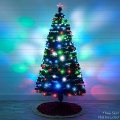 a brightly lit christmas tree in front of a wall