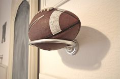 a football hanging from a hook on a door handle in the shape of a football