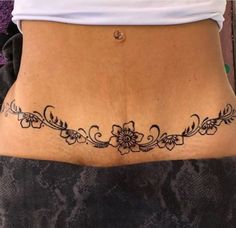 a woman's lower back tattoo with flowers on it