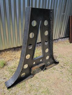 a metal object sitting in the grass next to a fence