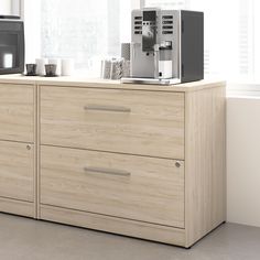 a coffee machine sitting on top of a wooden dresser next to a microwave and toaster