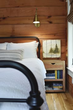 a bedroom with wood paneling and white bedding