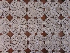 an old crocheted doily is displayed on a wooden surface