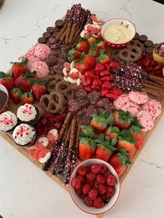 a platter with strawberries, pretzels, cookies and other desserts