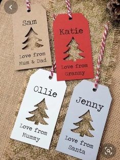 three tags with christmas trees on them are hanging from twine string and decorated with twine