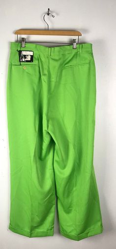 "-Description- >men's lime green wide leg swing pants >pleated >clip and zipper front >belt loops >open pockets in the front >one open and one button close pocket in the back >cuffs >new old stock - original tags still attached >size 34 waist >so disco! >condition: new old stock >color(s): lime green >fabric(s): 100 polyester >brand: smokey joes >care: dry clean -Measurements- >size: 34 waist ✩ all measurements are taken with the item laying flat & Retro Wide Leg Solid Bottoms, Retro Solid Color Bottoms For Spring, Retro Spring Bottoms, Retro Green Bottoms For Spring, Vintage High-waisted Green Pants, Retro Green Pants With Pockets, Vintage Green High-waisted Pants, Retro Green Wide Leg Bottoms, Retro Wide Leg Solid Color Pants