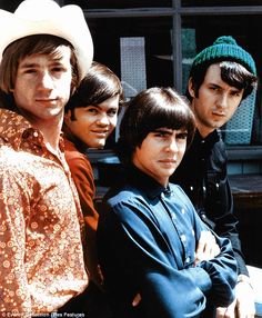 four young men are posing together in front of a building