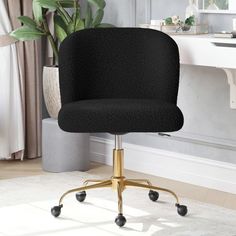 a black office chair sitting on top of a white rug next to a potted plant