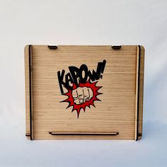 a wooden box with the word kapow painted on it