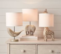 two lamps on a dresser with an elephant and giraffe figurine