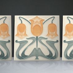 three tiles with designs on them sitting on a table