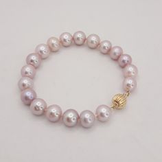 "This beautiful freshwater pearl bracelet is stunning.  The pearls are very slightly different shades of blush with hints of gray.  The pearls have some of the unique imperfections that show the pearls are genuine.  They are joined together by a 14 kt. gold fluted bead clasp.  The clasp is marked and has been tested for 14 kt. gold. This bracelet is 7 1/2\" long and in excellent condition.  This bracelet is perfect for a bride or gift for her!" Rose Gold Pearl Bracelet With Round Beads, Elegant Pink Pearl Bracelet With 8mm Beads, Gift Pearl Bracelet With High Luster Round Beads, High Luster Pearl Bracelet With Round Beads As Gift, Gift Pearl Bracelet With High Luster, Pink Elegant Single Strand Beaded Bracelets, Elegant Pink Single Strand Beaded Bracelets, Elegant Pink Pearl Bracelet With Round Beads, Pink Pearl Bracelet With Round Beads For Formal Occasions