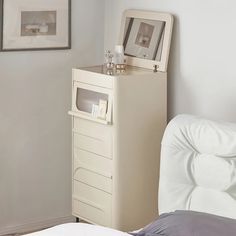 a bedroom with a bed and a white cabinet