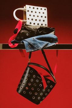 two purses are hanging from a rack on a red background with polka dot designs