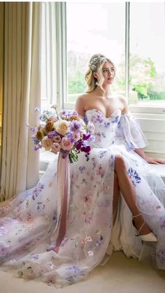 a woman sitting on a window sill with flowers in her dress