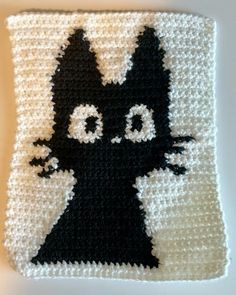 a crocheted black and white square with an image of a cat on it