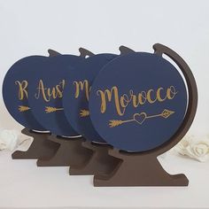 three wooden coasters with gold lettering on them