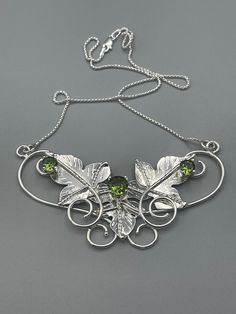 I've designed three sterling silver inspired leaves (with gentle vine work) which cradle an 8mm center gemstone of your choosing, with two side 6mm faceted Gems to offer symmetry and balance. This piece is approximately 1 and 1/4 inches in height and 2 and 1/4 inches across, but each may vary since I do make each one by hand - subtle variances will occur in the fabrication of the pendant. The pendant will come with an 18 inch, 1.2mm thick box chain, in sterling silver, with a lobster claw attach Elegant Hand Forged Green Jewelry, Nature-inspired Silver Jewelry With May Birthstone, Nature-inspired Silver Jewelry With Emerald, Elegant Green Hand-forged Jewelry, Wire Weaving Tutorial, Real Gold Chains, Felt Pouch, Metalwork Jewelry, Faceted Gems