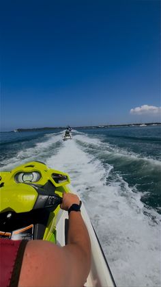 a person on a jet ski riding through the water with another boat in the background