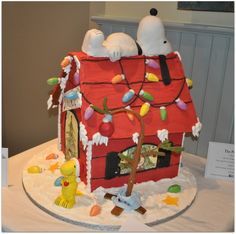 a cake made to look like a house with peanuts on the roof and decorations around it