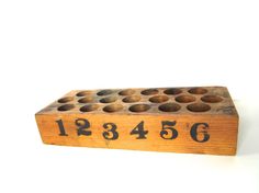 a wooden block with numbers on it and holes in the middle that have been cut out