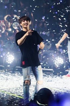 a man standing on top of a stage with confetti in the air behind him