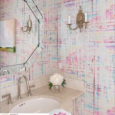 a white sink sitting under a bathroom mirror next to a wall mounted faucet