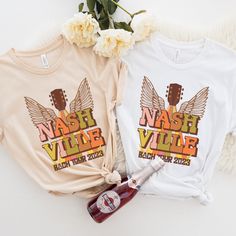 two t - shirts with the words mash and vine on them next to a bottle of wine