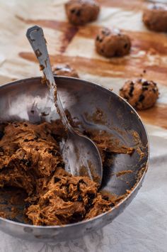 a metal bowl filled with chocolate cookies on top of a table