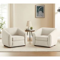 two white chairs sitting on top of a rug in a living room next to a lamp