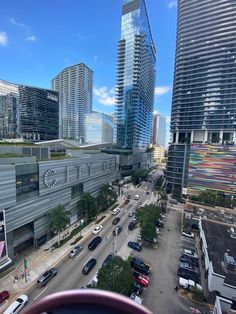 an aerial view of a city with tall buildings and cars driving down the street in front of them