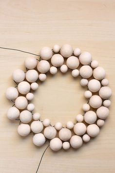 a bunch of white balls are arranged in the shape of a letter o on a wooden surface