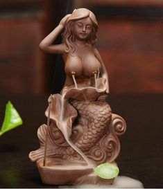 a statue of a woman sitting on top of a fish