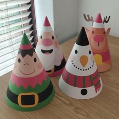 three christmas themed party hats sitting on top of a wooden table next to a window