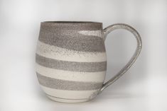 a gray and white striped coffee mug