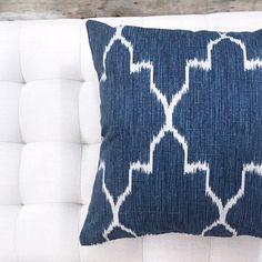 a blue and white pillow sitting on top of a couch