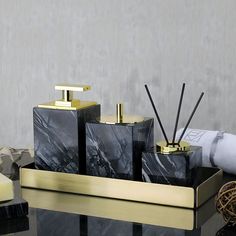 black and gold bathroom accessories sitting on a table