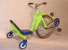 a green scooter sitting on top of a wooden floor next to a wall