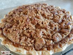 a pie sitting on top of a glass plate covered in crumbly toppings