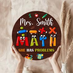 two hands holding up a wooden sign that says, mrs smith math she has problems