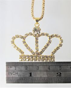 Gold or Silver Jewel Encrusted Crown Pendant, These crown necklaces are perfect for all royalty with all their rhinestones. They would make an exceptional gift for a fashionista. They are exquisite and would make an excellent charm or just as a collectible for the designer at heart. The are about 1.5 in x 2 in and they come with a 28" chain. Metal Rhinestone Necklace For Gift, Regal Gold Jewelry With Crown Design, Metal Necklace With Rhinestones For Gifts, Metal Necklaces With Rhinestones For Gifts, Dainty Metal Necklace With Rhinestones For Gift, Costume Jewelry With Rhinestones For Gifts, Metal Rhinestone Pendant Necklace, Party Pendant Rhinestone Necklace With Bling, Rhinestone Crystal Pendant Necklace With Bling