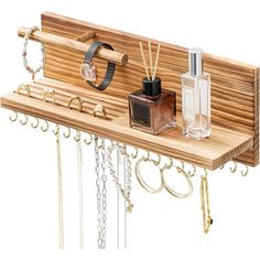 a wooden shelf with jewelry hanging from it's sides and two bottles on top