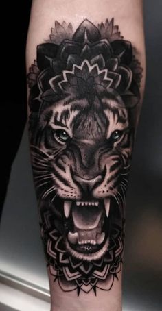 a black and white tiger with a flower on it's head is shown in this tattoo